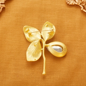 Vintage gold four-leaf clover brooch with teardrop crystal and pin back detail