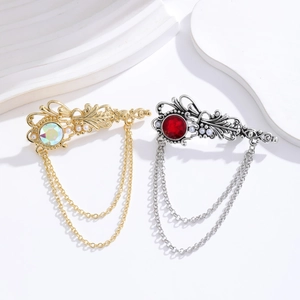 Vintage baroque brooches with crystals, pearls and metal tassels on white background