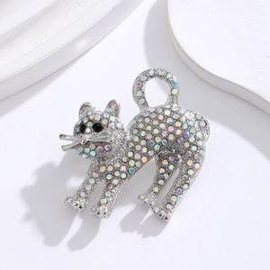 Broche chat scintillante avec strass colorés sur fond blanc minimaliste et élégant