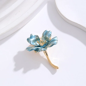 Broche fleur de cerisier élégante en émail bleu ciel et placage or sur fond blanc