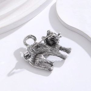 Broche chat argentée vintage avec métal brossé et épingle détaillée sur support blanc
