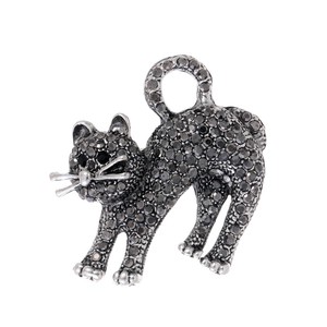 Gros plan d'une broche chat sertie de cristaux gris foncé avec des yeux en pierres noires