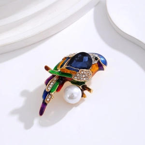 Detailed close-up of parrot brooch with blue enamel, pear-cut gemstone and large white pearl