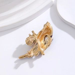 Golden parrot brooch with blue enamel and sparkling crystals on white background