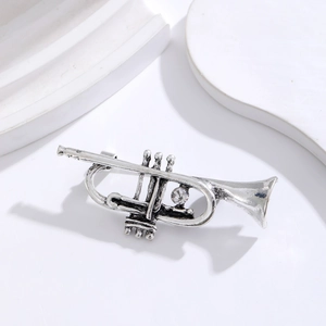 Detailed macro view of vintage silver trumpet brooch with sparkling center crystal