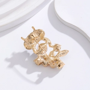 Back view of owl flower brooch in gold finish with pin closure and pearl inlay