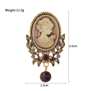 Vintage Baroque oval cameo brooch with red gemstone drop and champagne rhinestones