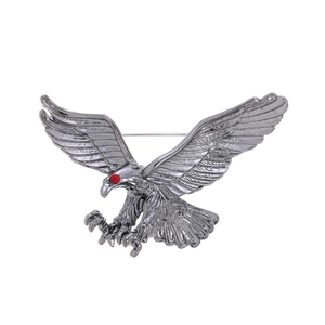 Minimalist eagle brooch for men with wings spread and a striking red rhinestone eye