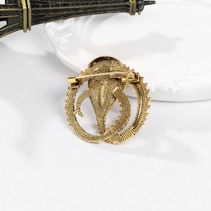 Vintage gold snake brooch back view showing secure safety pin and metallic texture