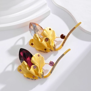 Elegant gold tulip brooch with purple and champagne crystals on white steps