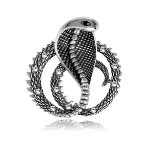 Macro detail of vintage cobra brooch with intricate silver scales and clear crystal stones
