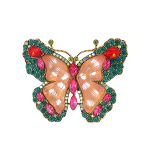 Detailed macro view of vintage butterfly brooch with colorful crystals and gold frame