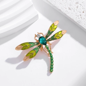 Elegant gold dragonfly brooch with green enamel wings and teardrop crystal stone