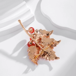Elegant maple leaf brooch in rose gold with red berries and secure safety pin back