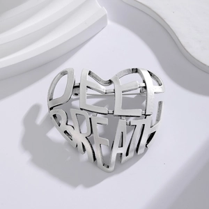 Vintage silver hollow heart brooch featuring Deep Breath cutout design on white stand