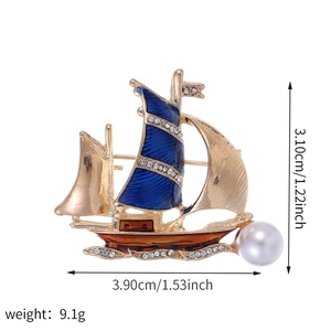 Broche voilier dorée avec émail bleu, strass scintillants et perle blanche élégante