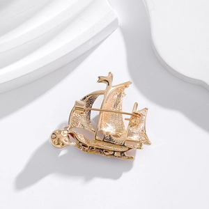 Vue arrière d'une broche voilier dorée avec finition métallique polie et fermoir épingle
