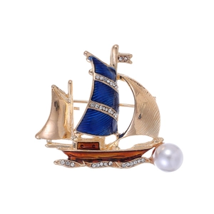Broche voilier dorée élégante avec émail bleu, strass blancs et accent perlé chic