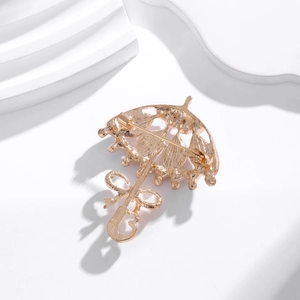 Rose gold umbrella brooch with cat's eye stone and crystals, macro view of the back pin