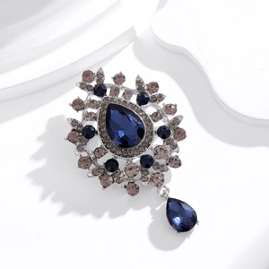 Spilla vintage stile palazzo con cristallo blu a goccia e ciondolo su base bianca