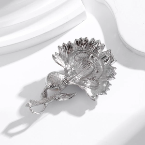 Broche fleur argentée avec perle, pétales texturés et fermoir épingle sur support blanc