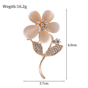 Pink opal flower brooch with crystal rhinestones and golden stem on white background