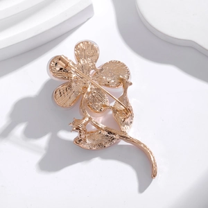Back view of flower cat eye opal brooch with golden metal pin closure on white background