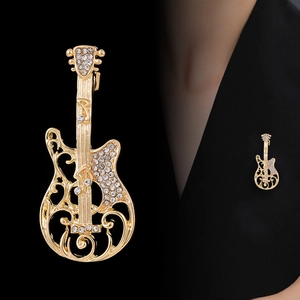 Elegant gold guitar brooch with white rhinestones on a black suit lapel, premium accessory