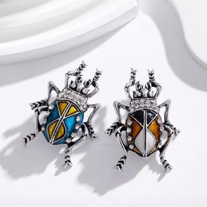 Spille a scarabeo vintage con finitura in smalto e strass di cristallo su sfondo bianco