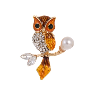 Elegante spilla a gufo in smalto arancione con zirconi e perla bianca su ramo dorato