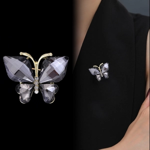 Broche papillon élégante en cristal gris et métal doré sur un costume noir chic
