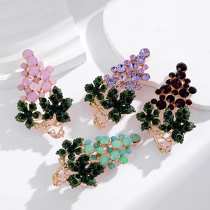 Macro detail of grape brooches with sparkling crystals and green rhinestone leaves