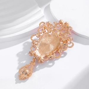 Broche baroque dorée avec pierres précieuses et pendentif goutte au design ajouré