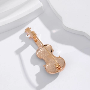 Vue arrière de la broche violon dorée montrant le fermoir sur support en pierre blanche