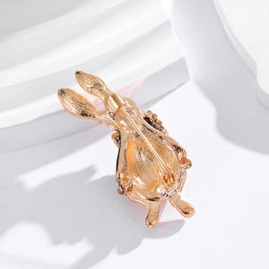 Golden bunny brooch with enamel and rhinestones shown from the back safety pin closure
