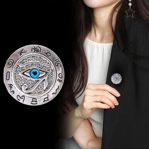 Silver Eye of Horus brooch with blue center and hieroglyphs on a black suit lapel
