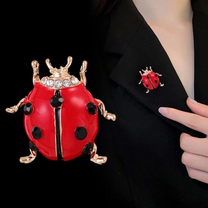 Chic ladybug brooch with red enamel and sparkling crystals on a black suit lapel
