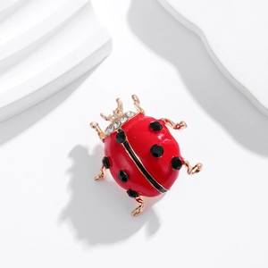 Cute ladybug brooch with red enamel and crystals on a white minimalist background