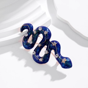 Vintage starry blue snake brooch with rhinestones and gold star accents on white steps