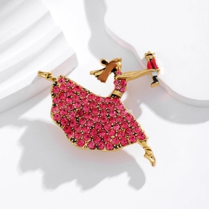 Broche ballerine dorée ornée de strass roses et d'une figurine de casse-noisette