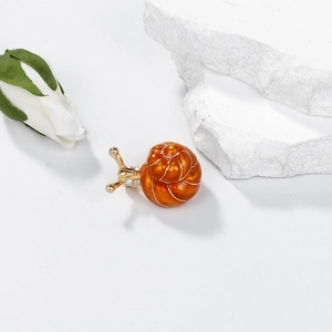 Eleganter Schnecken-Anstecker in Gold mit orangefarbenem Emaille und Strasssteinen