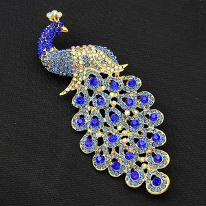 Elegant peacock brooch with royal blue crystals and gold alloy base on black background