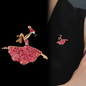 Broche ballerine dorée avec strass roses et casse-noisette sur le revers d'un blazer noir