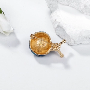 Eleganter goldener Schnecken-Anstecker mit blauem Emaille auf weißem Hintergrund