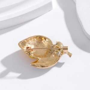 Polished lemon fruit brooch in gold plating showing the back metal texture and pin clasp