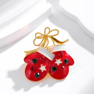 Christmas red glove brooch with gold bow and colorful rhinestones on a white pedestal