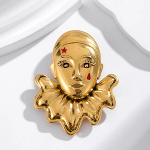 Vintage gold clown mask brooch with red star and teardrop on white background