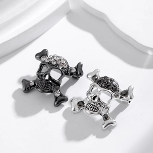 Broche style punk gothique avec tête de mort et os croisés sertis de strass brillants