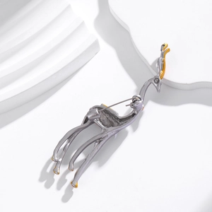 Back view of silver giraffe brooch with yellow details and secure pin closure