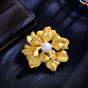 Elegant gold peony flower brooch with white pearl and sparkling rhinestones on blue silk